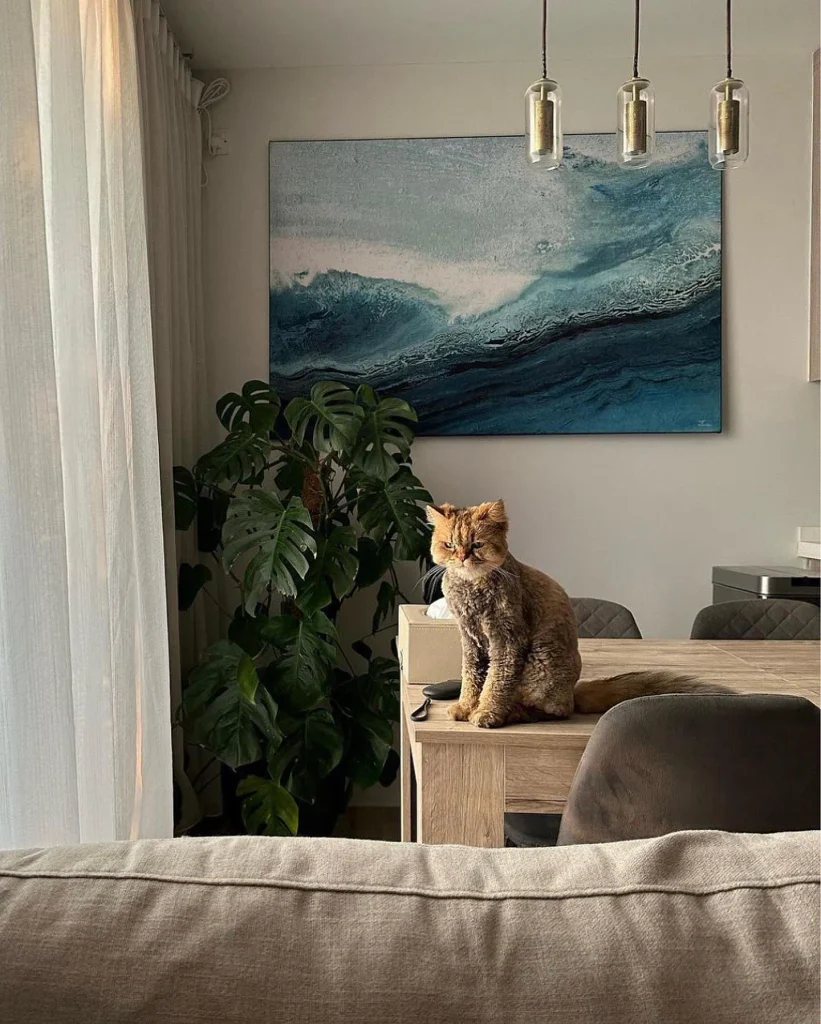 abstract wave wall art in a living room with a cat on the table